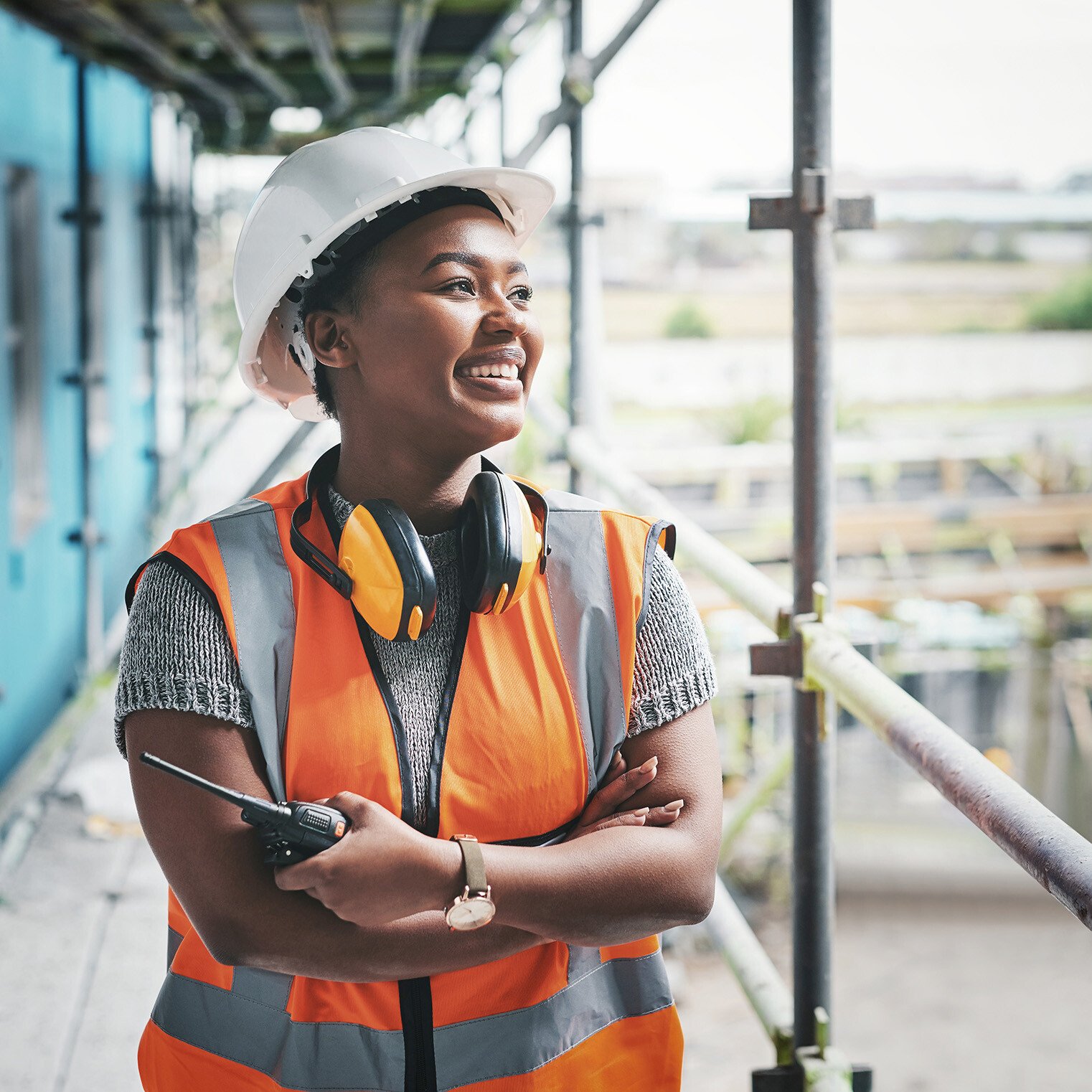 smiling calibration service provider with a walkie talkie and hard hat